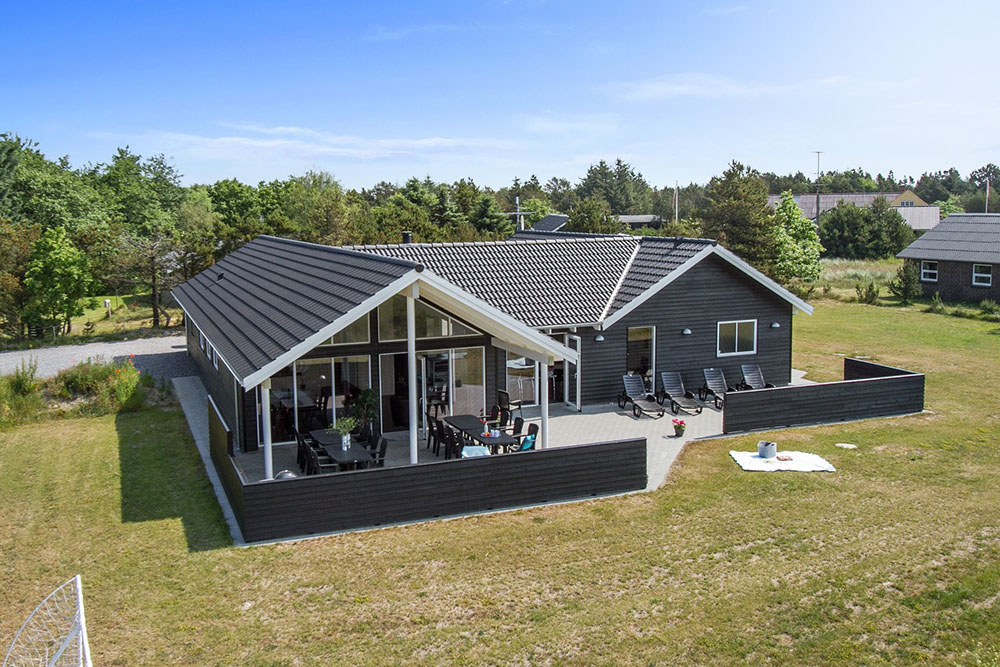 Dette eksklusive luksussommerhuset ligger i et ettertraktet sommerhusområde like ved stranden og den sjarmerende feriebyen Blåvand
