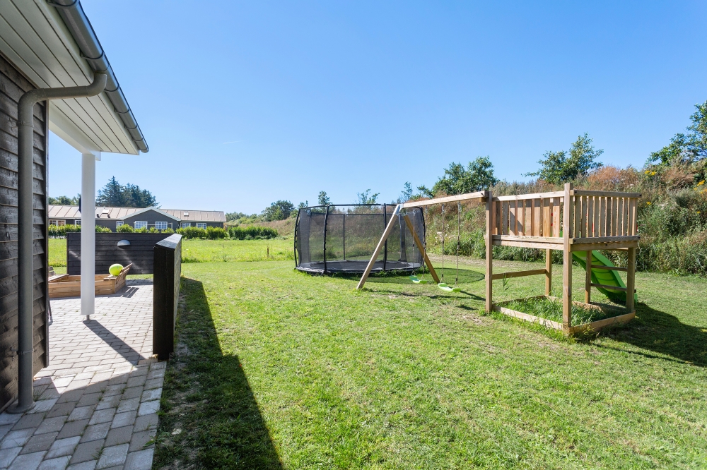 I det attraktive feriehuset nr. 523 i Nordjylland finnes det mengder av utendørsaktiviteter, som leketårn og huskestativ.